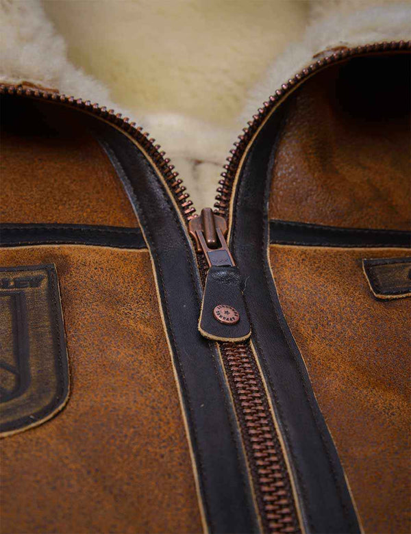 Metal zipper on men's light brown sheepskin vest.