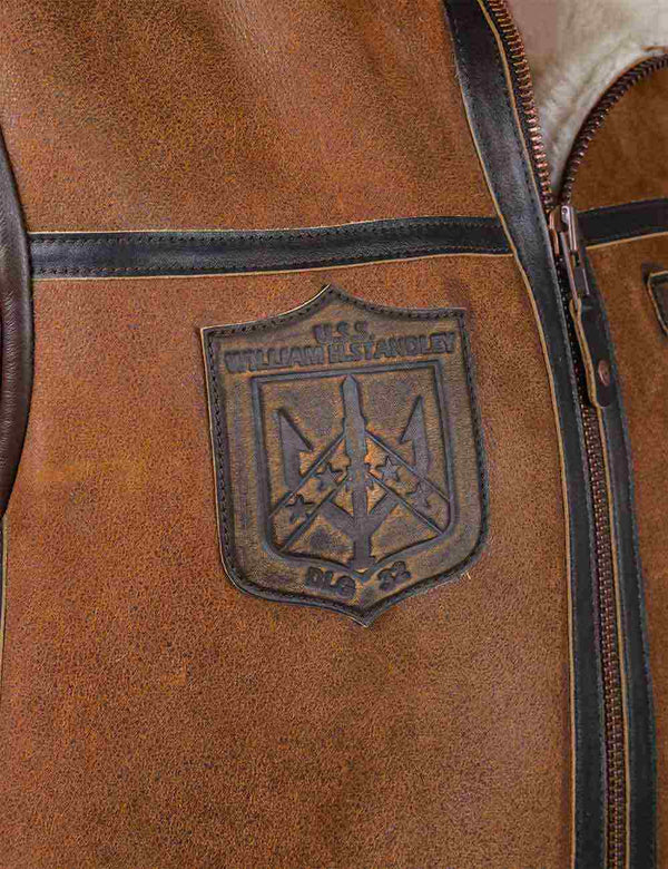 Leather patch on the chest of a men's light brown sheepskin vest.