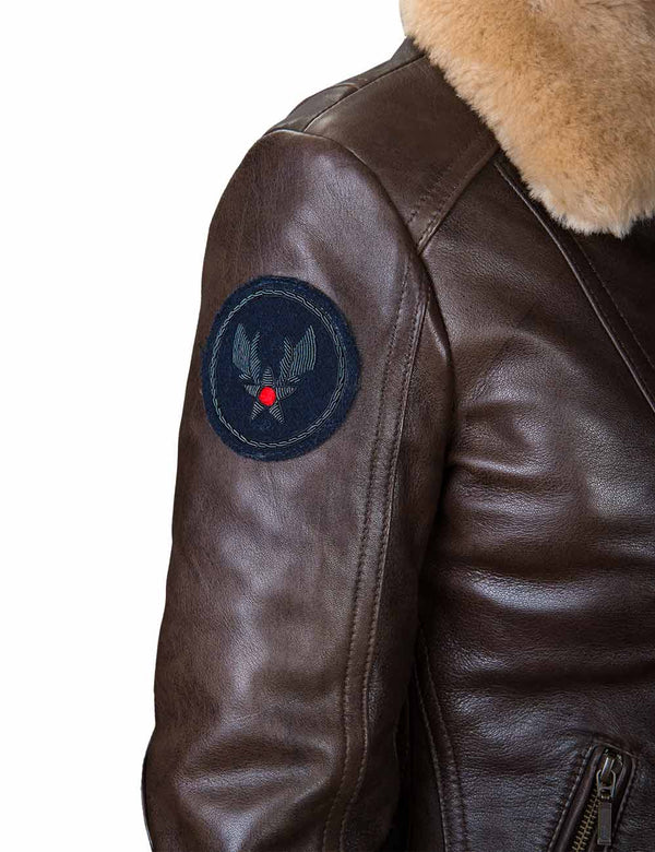 Round patch on the sleeve of a women's brown leather jacket.